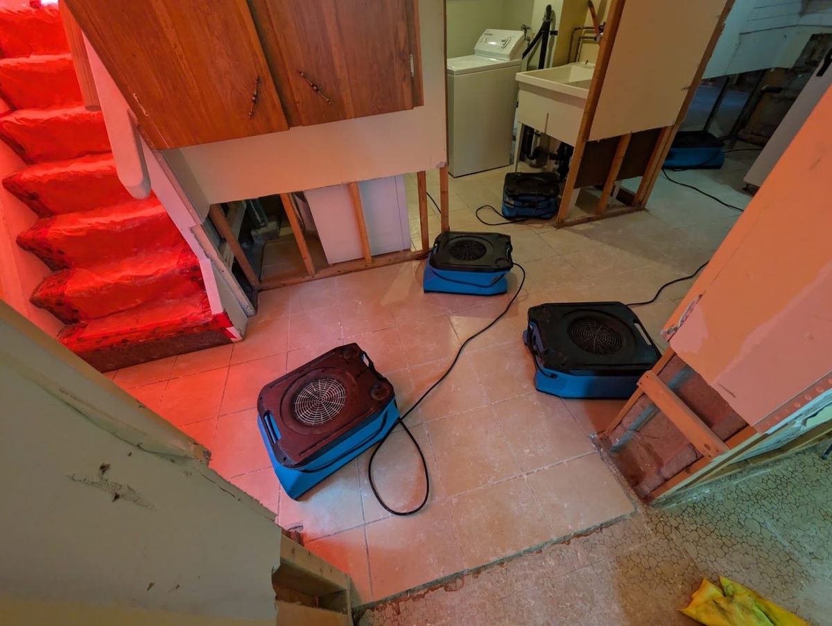 Air movers drying a finished basement and stairwell after water damage