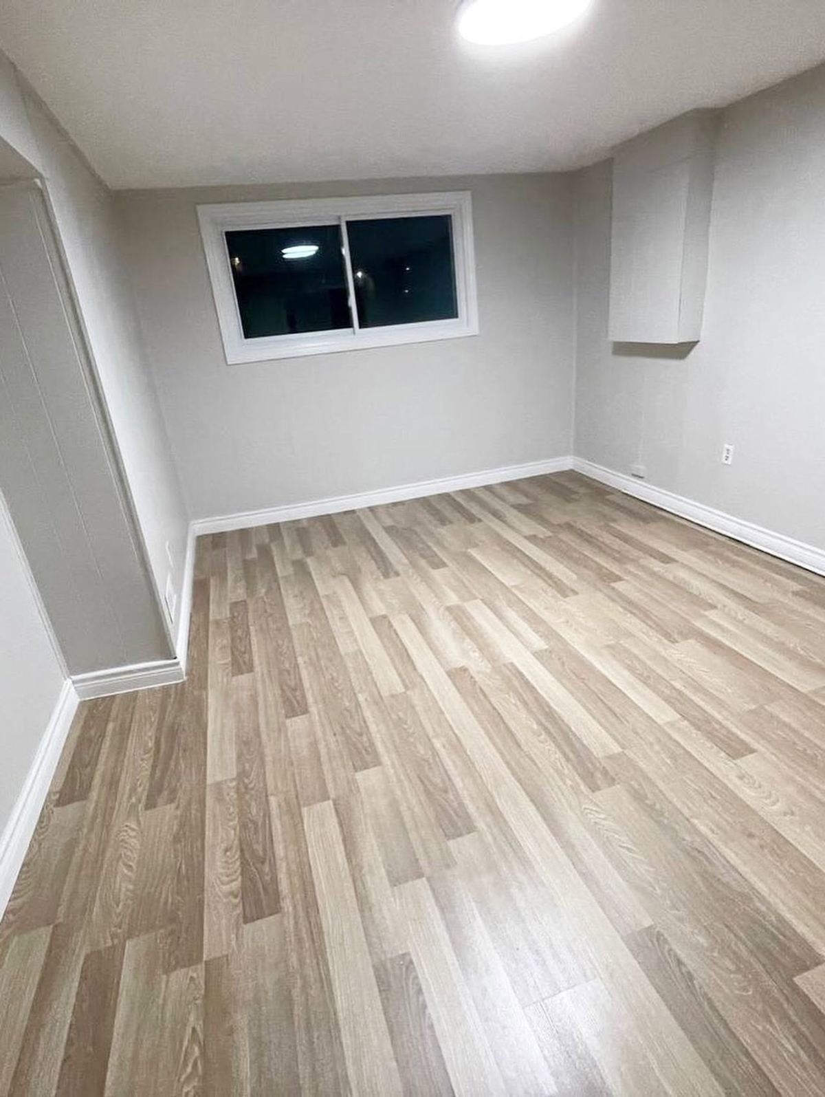 Finished basement with new walls and laminate flooring after water damage restoration