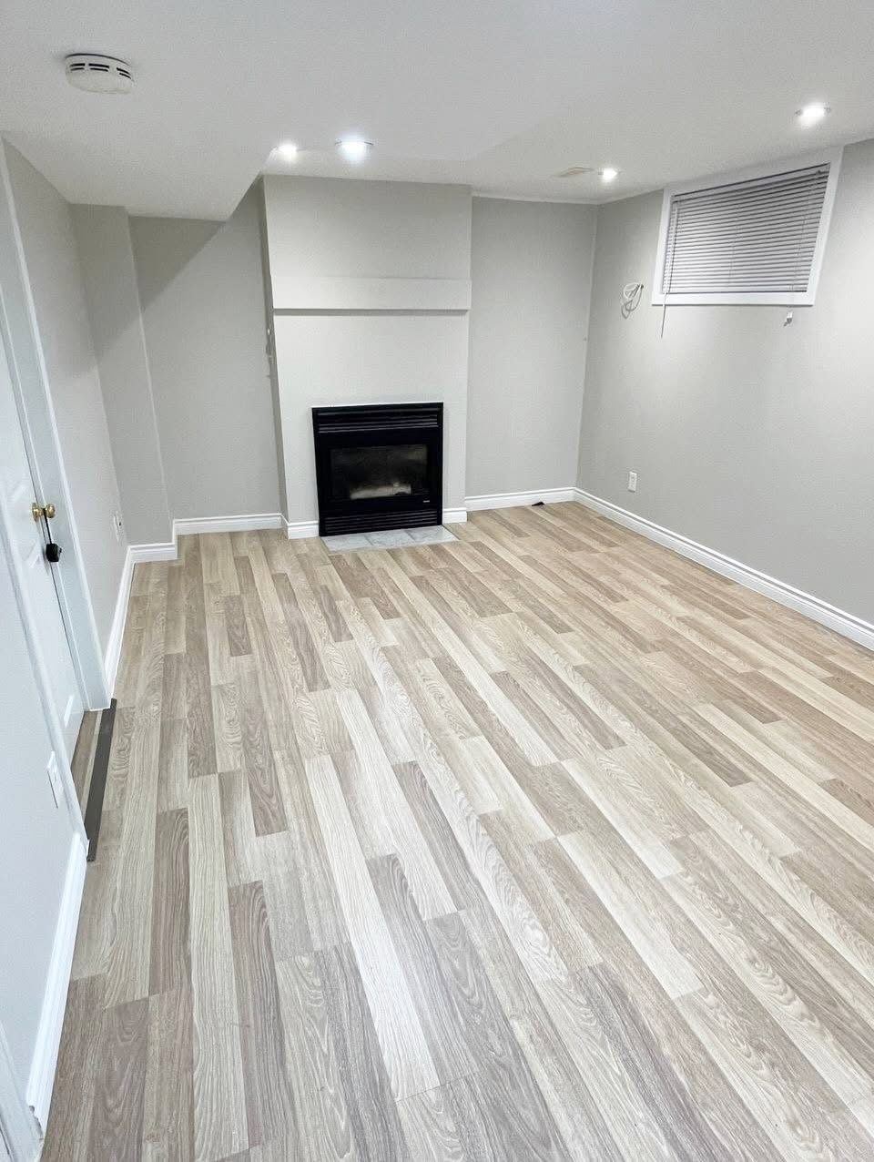 Finished basement with fireplace and new flooring after restoration