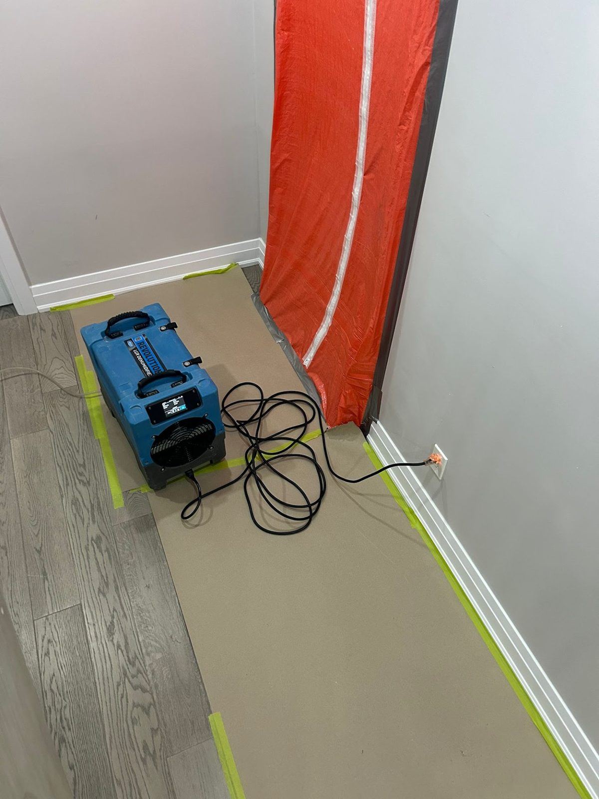Zippered plastic containment door and dehumidifier set up for mold removal